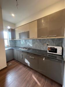 a kitchen with stainless steel cabinets and a microwave at Fellows BnB in Dhok Sandemār