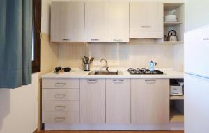 eine Küche mit weißen Schränken und einer Spüle in der Unterkunft Beach Front Home In Marina Di Modica in Marina di Modica