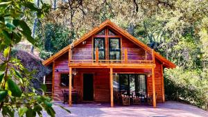 a log cabin with tables and chairs in front of it at CABAÑAS DEL BOSQUE CERCA DE CORDOBA in Córdoba
