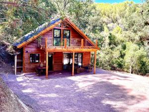 a log cabin in the woods with a porch at CABAÑAS DEL BOSQUE CERCA DE CORDOBA in Córdoba