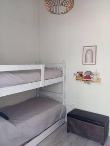 a bedroom with two bunk beds and a ottoman at Hermosa Casa en El Ensueño Santa Ana Colonia in Santa Ana