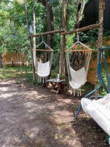 deux chaises hamac et une table dans une forêt dans l'établissement Hermosa Casa en El Ensueño Santa Ana Colonia, à Santa Ana 12 autres photos
