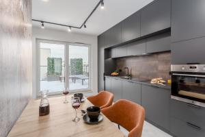 ワルシャワにあるJacuzzi Hideout - Warsaw private terrace - Free Parkingのキッチン(木製テーブル、椅子2脚付)、ダイニングルームが備わります。