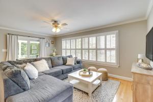 a living room with a blue couch and a table at Water-View Deale Home Walk to Marina, Restaurants in Deale