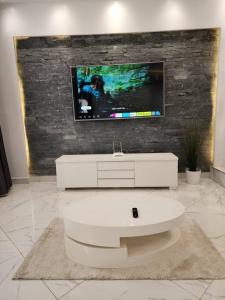 a living room with a tv on a brick wall at Tranquility Inn in Buzzi +18 photos