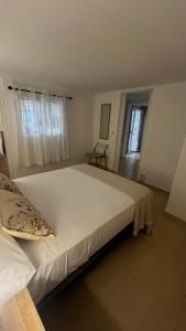 Una cama blanca grande en una habitación con ventana. en Casa Anita, en Fuengirola