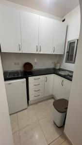 cocina con armarios blancos, lavabo y aseo en Casa Anita, en Fuengirola