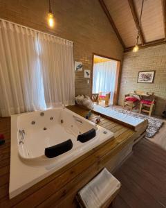 a large white bath tub in a room at Chalés Villa Caravaggio in Santa Teresa