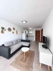 a living room with a couch and a table at Apartamento Playa Cañon del águila in Playa del Aguila +19 photos