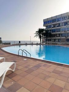 a large swimming pool in front of a building at Apartamento Playa Cañon del águila in Playa del Aguila