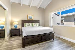 a bedroom with a large bed and a window at Stunning 2nd Floor Beachfront Home with Balcony, Ocean Views, and Prime Location in Newport Beach