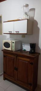 a microwave sitting on top of a wooden table at Casa Aconchegante in São Sebastião