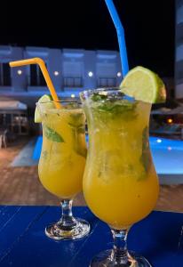 dos bebidas sentadas en una mesa con rodajas de lima y lima en Hotel Adriatik Orikum, en Orikum