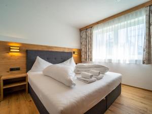 a bedroom with a large white bed with towels on it at Chalet Pettneu am Arlberg - Top 2 in Pettneu am Arlberg