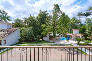 a house with a fence and a pool at Casa Caiçarinha perto do centro com ar e piscina in Paraty
