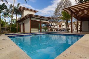 a swimming pool in front of a house at Casa Caiçarinha perto do centro com ar e piscina in Paraty