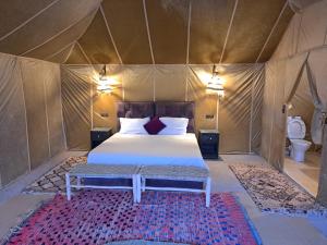 a bedroom with a bed in a tent at Berber Merzouga Luxury Camp in Merzouga