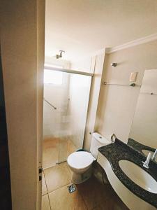 a bathroom with a toilet and a sink and a shower at Thermas place 406 in Caldas Novas +7 photos