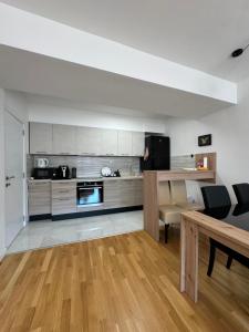 a kitchen with white cabinets and a table and chairs at Cozy apartment-center of Skopje in Skopje