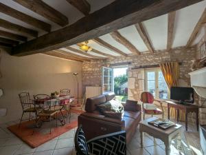 un soggiorno con un divano e un tavolo di Maison rénovée au cœur du Parc Naturel de la Brenne avec jardin et terrasse - FR-1-591-44 a Saint-Aigny