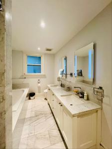 a bathroom with two sinks and a tub and a toilet at Meet友缘 in Vancouver