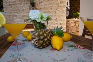 a pineapple sitting on a table with two glasses of juice at Villa Zara in Trogir
