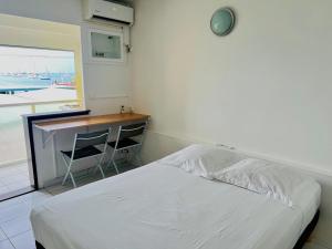 um quarto com uma cama, uma escrivaninha e uma janela em Les Trois Ilets Location Studio Face a la Mer em Les Trois-Îlets