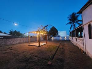 a basketball hoop with lights in a yard at night at Casa Ilha de Itaparica Bahia in Ilha de Itaparica