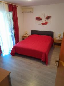 - une chambre avec un lit rouge et une couverture rouge dans l'établissement Apartments with parking space Kneza, Korcula - 23421, à Pupnat