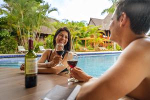 a man and woman sitting at a table with wine glasses at IKAM Riverview Amazon Lodge - Asociado Casa Andina in Puerto Maldonado