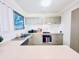 北湖Calm Hideaway - Townhouse with Pool Access & Garage的带水槽和炉灶的白色厨房