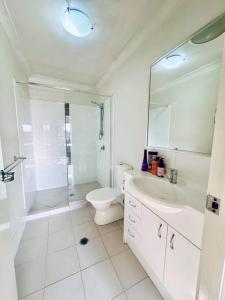 北湖Calm Hideaway - Townhouse with Pool Access & Garage的配有马桶、淋浴和水槽的浴室