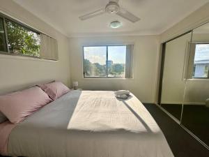 北湖Calm Hideaway - Townhouse with Pool Access & Garage的带床和吊扇的卧室