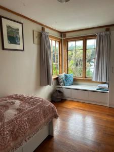 a bedroom with a bed and a window seat at Character Harbour Retreat in Dunedin