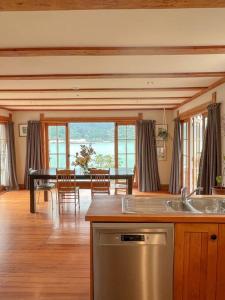 a kitchen with a table and a dining room with a view at Character Harbour Retreat in Dunedin