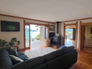 a living room with a couch and a flat screen tv at Character Harbour Retreat in Dunedin