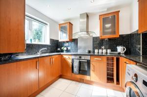 a kitchen with wooden cabinets and a sink at Classic 2bedroom Apartment in Mill Hill +8 photos