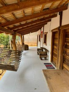 an outdoor patio with benches and a wooden ceiling at Pousada Peraputanga in Estivado +19 photos
