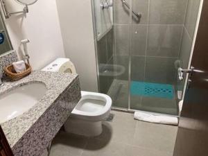 a bathroom with a toilet and a sink and a shower at Via Première - Suíte - Riocentro - Barra Olímpica - Vista Panorâmica in Rio de Janeiro