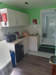 a kitchen with white cabinets and a sink and a tub at The Lighthouse Studio Appartments in Nuku‘alofa