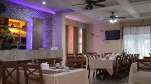 a dining room with tables and chairs and purple lighting at Nikita Hotel in Bukittinggi