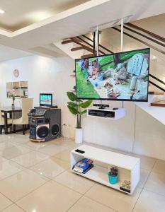 a living room with a flat screen tv on a wall at Homey & spacious with private plunge pool ktv near SMtela in Santo Domingo