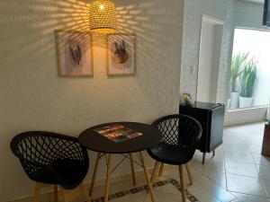 a table and chairs in a room with a light at Top´s Motel (Adult Only) in Jacareí
