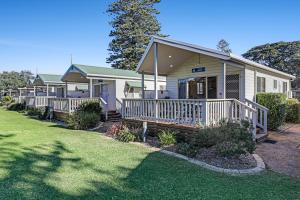 una casa con porche y patio en Werri Beach Holiday Park, en Gerringong