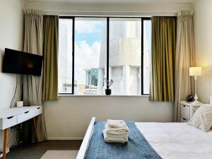 Uma cama ou camas num quarto em Skytower views, washer & dryer, TV!