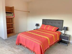 a bedroom with a bed with a red and yellow blanket at La Morada del Santuario in San Cristóbal de Las Casas