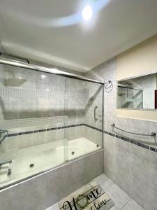 a bathroom with a tub and a glass shower at Grande y exclusivo, Cuenca cerca Parque Calderon, Mall del Río Seguridad 24 horas, 3 parqueos in Turi