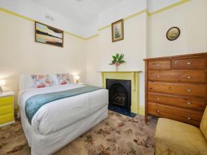 1 dormitorio con 1 cama, vestidor y chimenea en The Outlook, en Leura