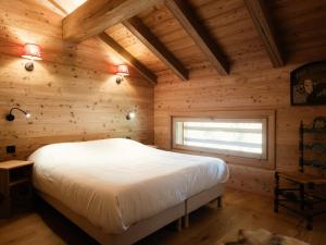 ein Schlafzimmer mit einem Bett in einem Holzzimmer in der Unterkunft Duplex 4★, 8 pers, cheminée, proche pistes - FR-1-304-295 in La Clusaz