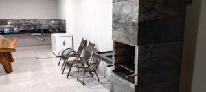 cocina con sillas y encimera con nevera en Lj eventos e lazer, en Porangatu 1 foto más